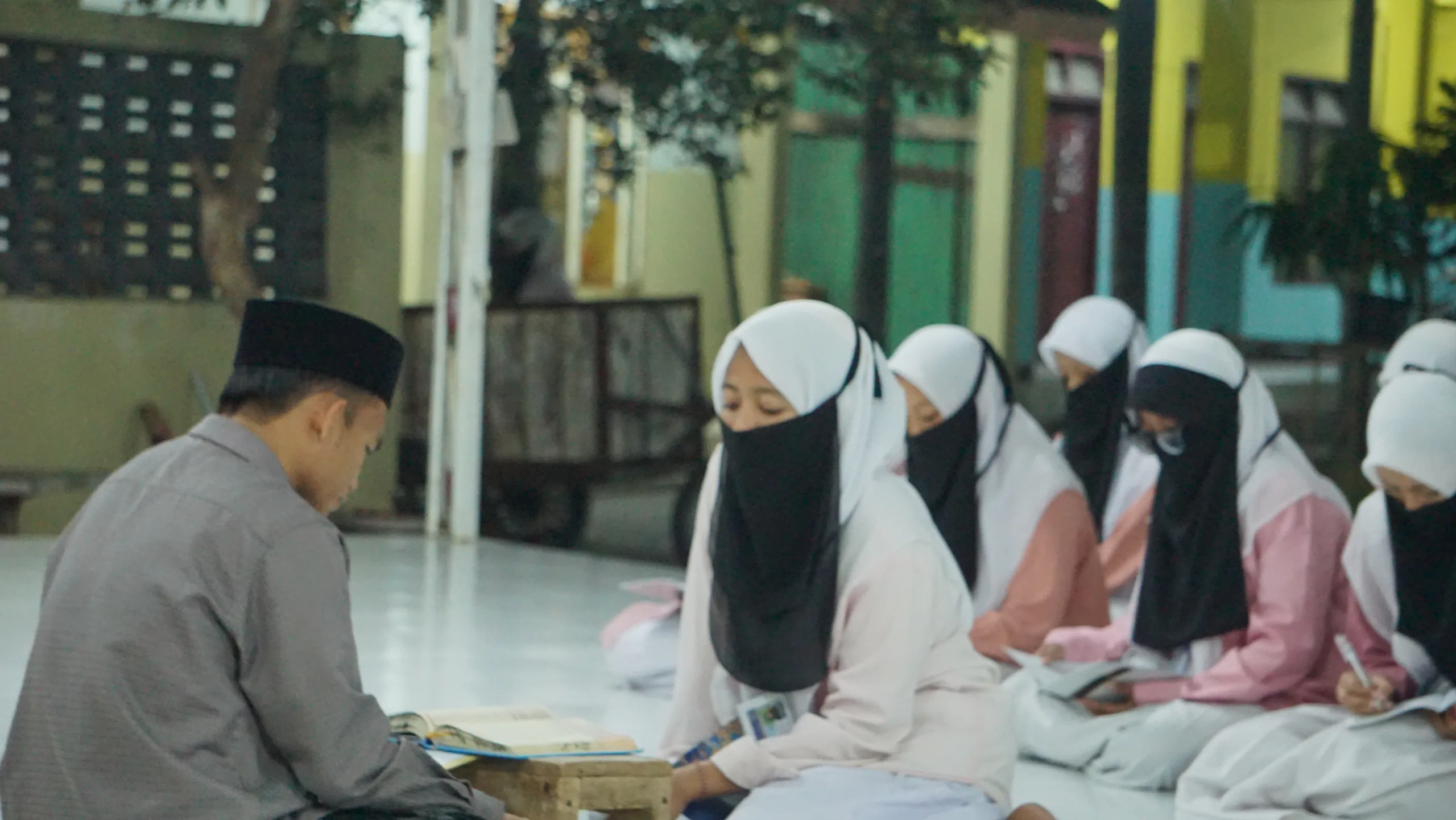 Santriwati duduk bersama mengikuti pembelajaran Al-Qur'an